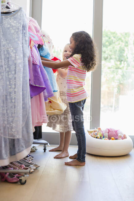 Dos niñas comprando en la tienda de ropa - foto de stock
