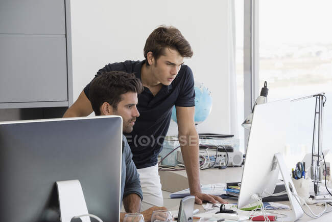 Два бизнес-руководителя, работающие за компьютером в офисе — стоковое фото