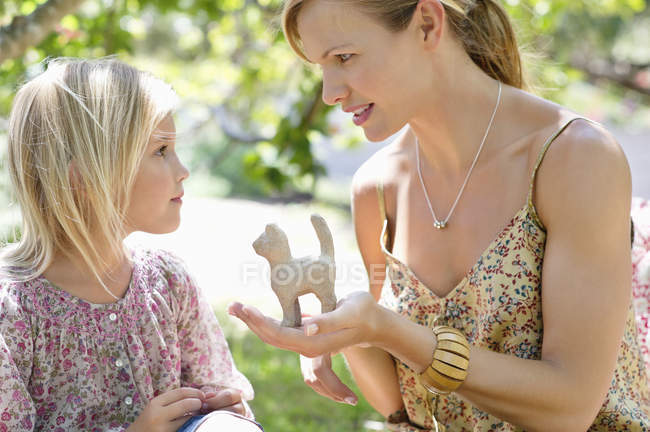 Bambina e madre guardando giocattolo in mano all'aperto — Foto stock