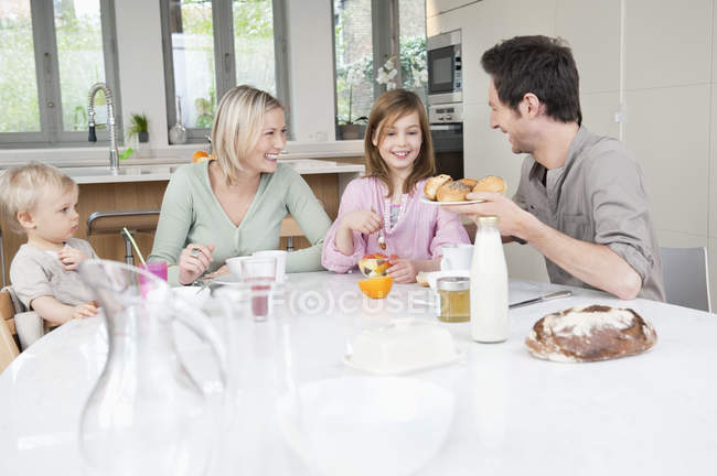 Happy family having fun at breakfast table — Stock Photo