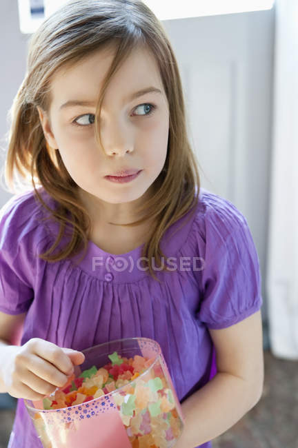 Retrato de menina segurando caixa cheia de balas de goma — Fotografia de Stock