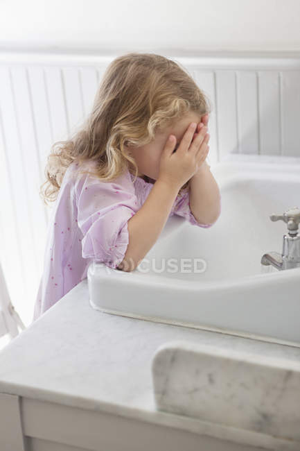 Bonito menina lavagem rosto no banheiro pia — Fotografia de Stock