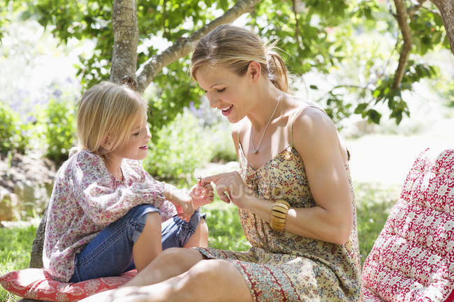 Mother and little girl sitting on backyard in summer — Stock Photo