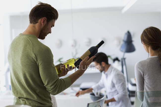 Nahaufnahme eines Mannes, der eine Weinflasche kontrolliert — Stockfoto