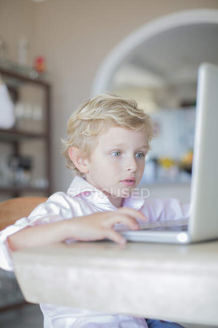 Маленький хлопчик з ноутбуком вдома — стокове фото