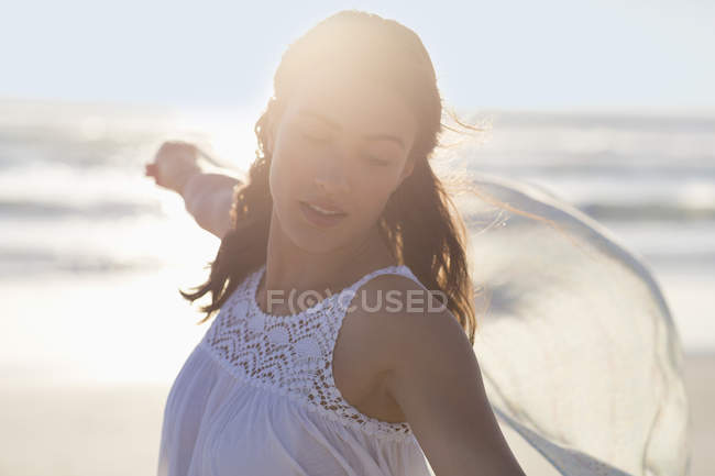 Happy young woman posing on beach in sunlight — Stock Photo