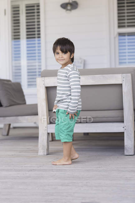 Ritratto di bambino sorridente in piedi in salotto — Foto stock