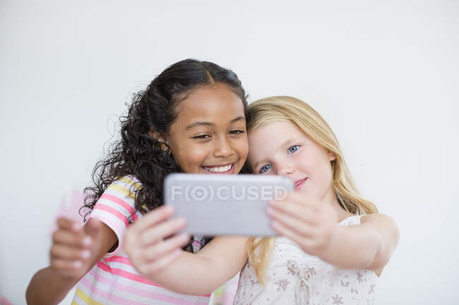 Dos niñas tomando selfie con el teléfono de la cámara - foto de stock