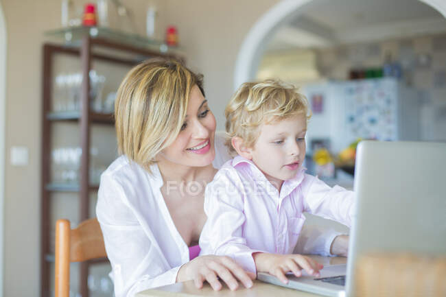 Madre e figlio con computer portatile a casa — Foto stock