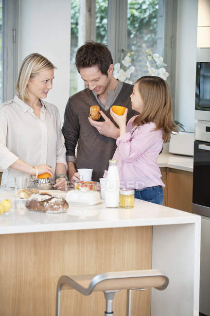 Famiglia che prepara la colazione in cucina moderna — Foto stock