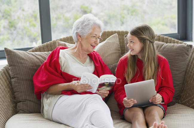 Seniorin und Enkelin schauen einander an und lächeln — Stockfoto