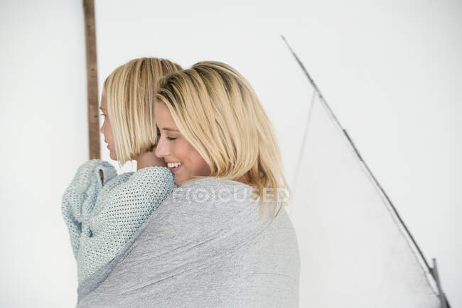 Feliz madre e hija sonriendo en casa - foto de stock