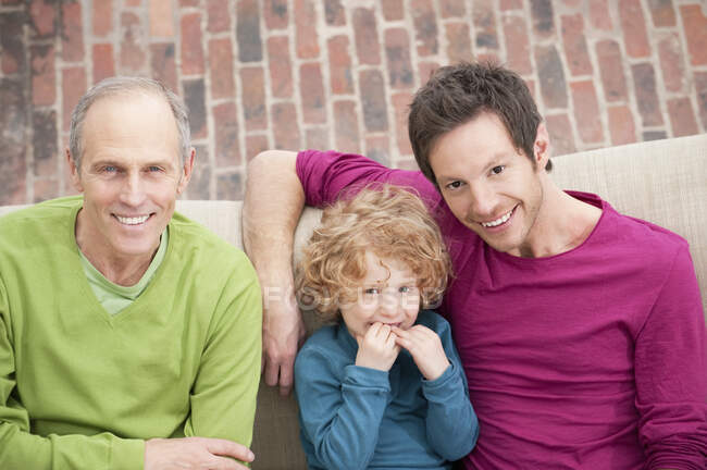 Familie lächelt zu Hause zusammen — Stockfoto
