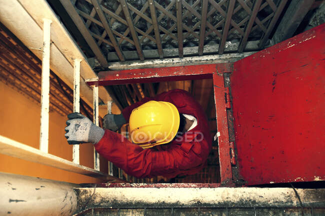 Workman climbing down a ladder. — Stock Photo