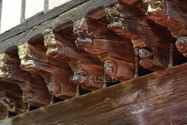 France, Ariège, figures sculptées sur les poutres en bois soutenant les maisons médiévales de Mirepoix — Photo de stock