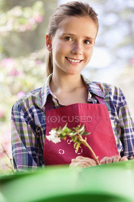 Menina pensativa no avental jardinagem ao ar livre — Fotografia de Stock