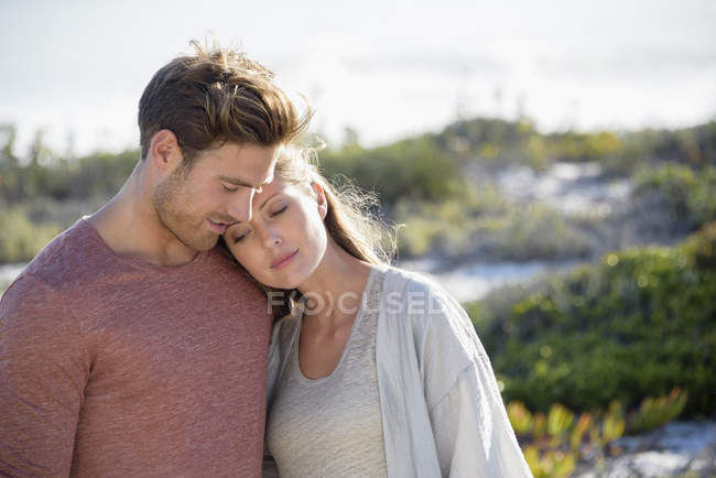 Pareja romántica relajada abrazándose en la costa juntos - foto de stock