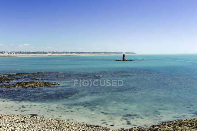Francia, Normandía, Granville. La costa y el faro visto desde el puerto. - foto de stock