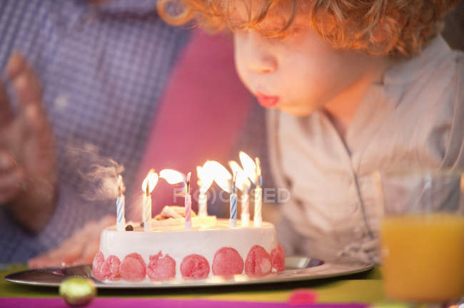 Cute little boy blowing out candles on birthday cake — Stock Photo
