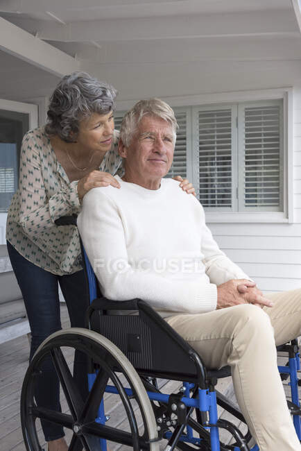 Homme âgé en fauteuil roulant avec sa femme sur le porche — Photo de stock