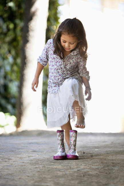 Menina bonito usando botas botas de borracha ao ar livre — Fotografia de Stock