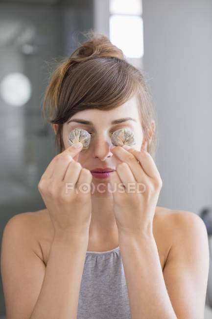 Ritratto di giovane donna che tiene le bustine di tè davanti agli occhi — Foto stock