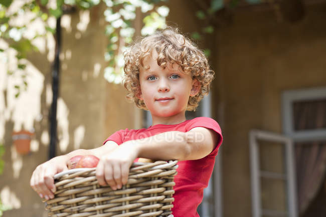 Portrait de petit garçon tenant panier de pommes fraîches cueillies à l'extérieur — Photo de stock