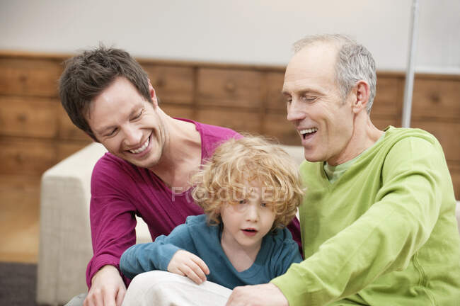 Familie lächelt zu Hause zusammen — Stockfoto