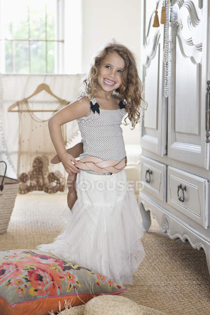 Niedliches kleines Mädchen, das sich mit übergroßen Kleidern der Mutter anzieht — Stockfoto