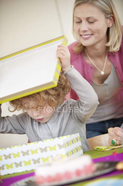 Мальчик открывает подарок на день рождения — стоковое фото