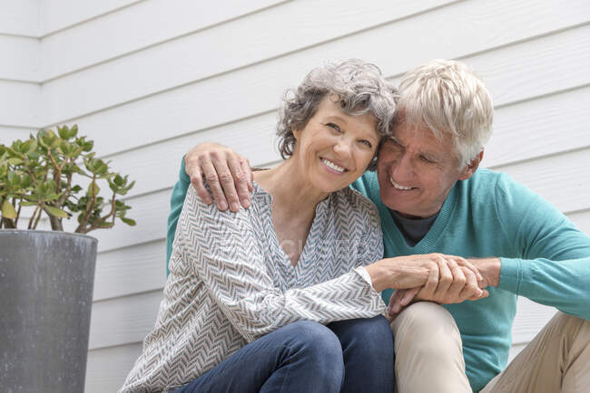 Aimer couple âgé assis à l'extérieur de la maison — Photo de stock