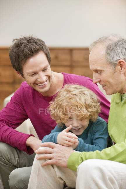 Familia sonriendo juntos en casa - foto de stock