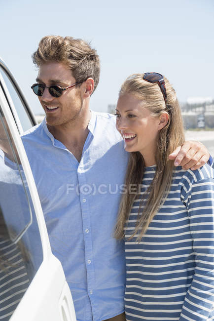 Happy couple getting into car for vacation — Stock Photo