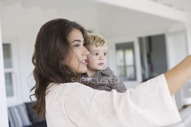 Elegante madre e figlio carino prendendo selfie a casa — Foto stock