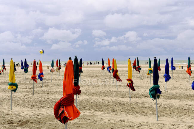 Франція, Північна Франція, Нижня Нормандія, Довіль, узбережжя перед бурею, парасольки. — стокове фото