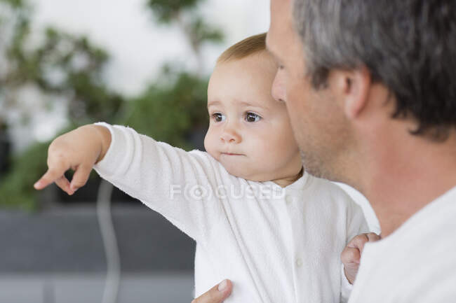 Крупный план отца со своей милой маленькой дочкой, указывающей — стоковое фото