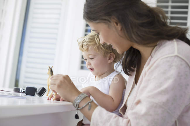 Mère heureuse jouant avec son fils à la maison — Photo de stock