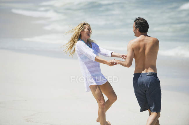 Brincalhão casal brincando na praia de areia — Fotografia de Stock