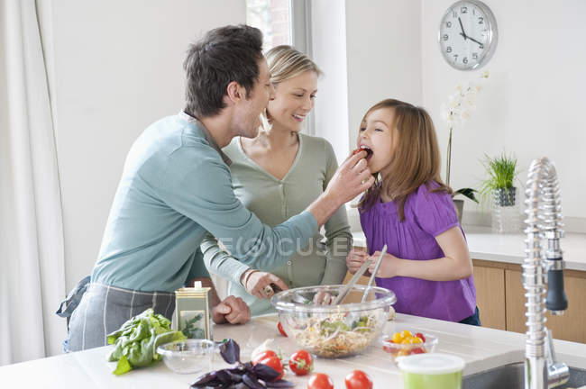 Happy family preparing food in kitchen — Stock Photo