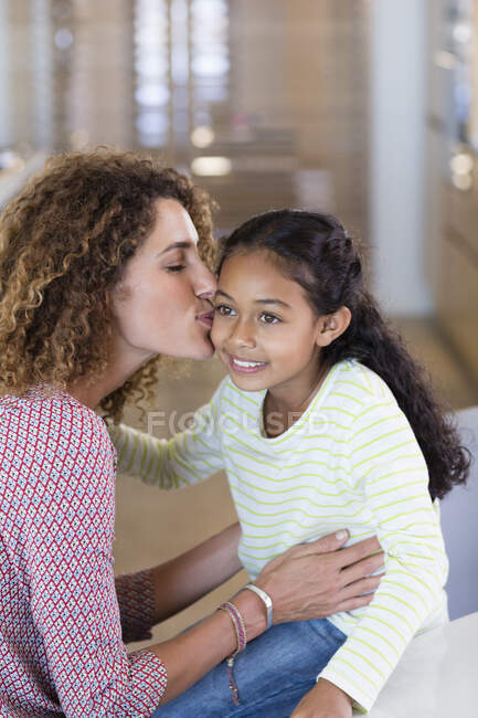 Feliz madre besando a su hija - foto de stock
