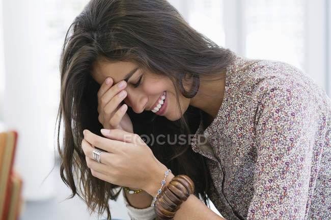 Brunette cheerful woman laughing with hands on face — Stock Photo