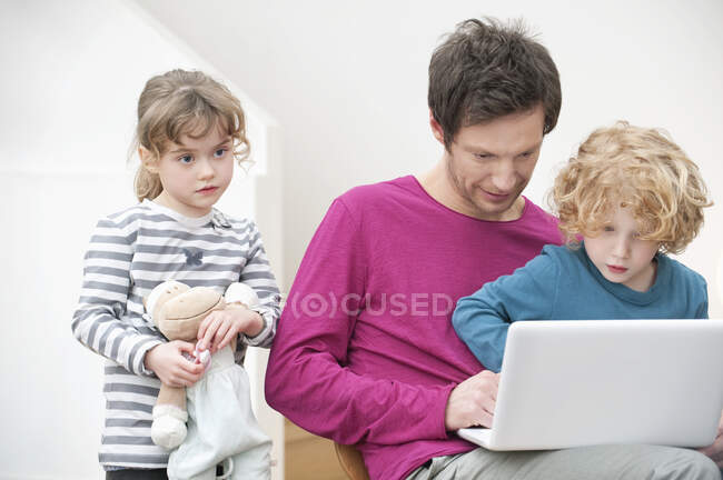 Крупним планом чоловік допомагає своєму синові використовувати ноутбук — стокове фото