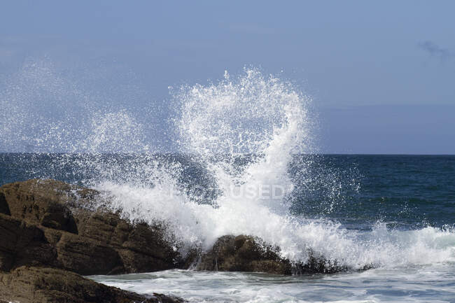 Francia, oeste de Francia, isla de Yeu, Pointe du But, olas sobre las rocas - foto de stock