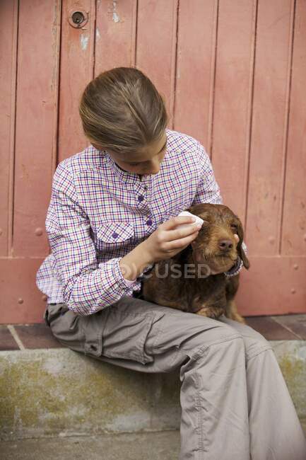 Giovane ragazza lavare gli occhi del suo cane — Foto stock