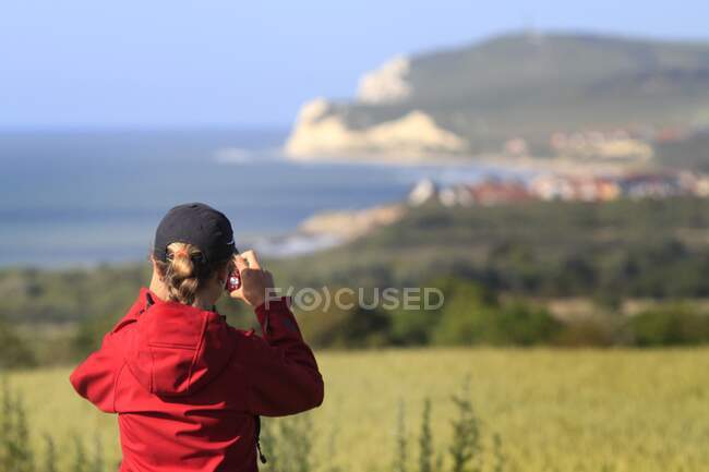 Francia, mujer de la costa norte tomando fotos - foto de stock