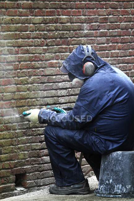 Países Bajos, hombre en el trabajo en la pared de ladrillo - foto de stock