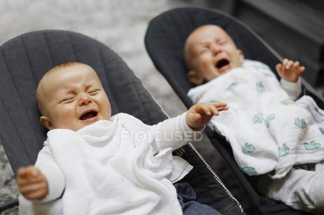 8-месячный мальчик двойняшки плачет — стоковое фото