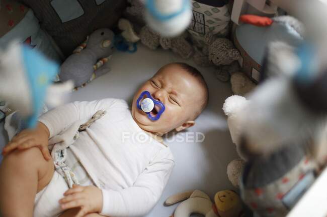 8 mois bébé garçon pleurer dans son lit — Photo de stock