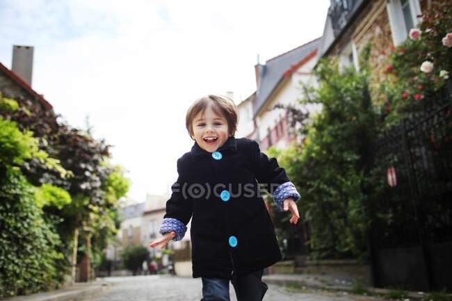 Little boy running in a cobbled narrow street — Stock Photo