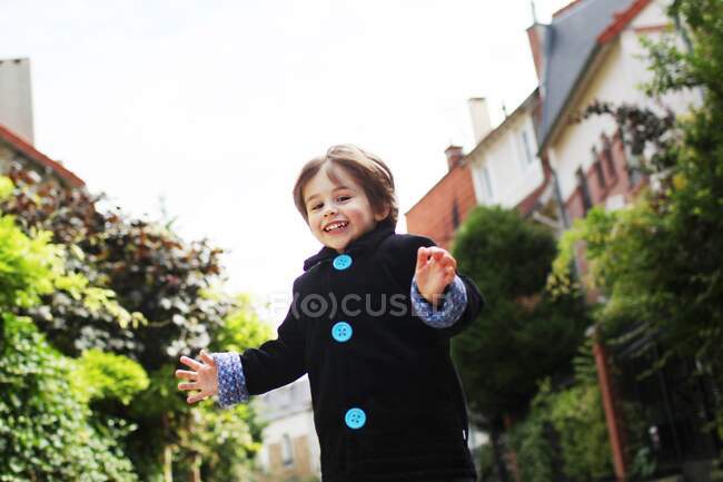 Маленький мальчик бежит по мощеной узкой улице — стоковое фото